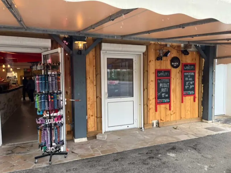 Entrée du Warlop's, devanture en bois avec ardoises menu