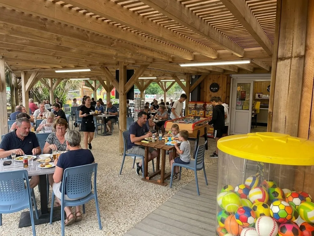 Terrasse couverte du Warlop's avec pergola en bois et tables familiales